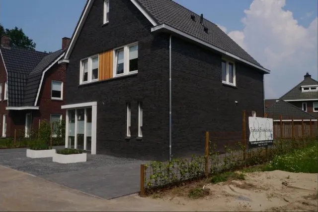 Zwarte woning met nieuw aangelegde omgeving